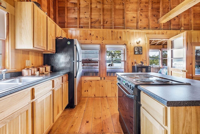 567 Phinney Farm Rd, Lincoln, ME 04457 - kitchen featuring electric stove, dark countertops, light wood-style floors, wooden walls, and a sink