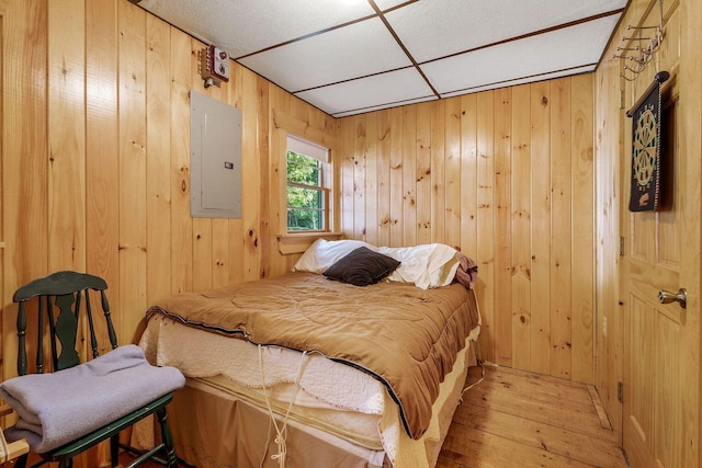 567 Phinney Farm Rd, Lincoln, ME 04457 - bedroom with electric panel, wooden walls, and hardwood / wood-style flooring