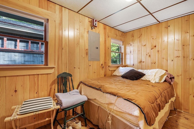 567 Phinney Farm Rd, Lincoln, ME 04457 - bedroom with electric panel, wood walls, and wood finished floors
