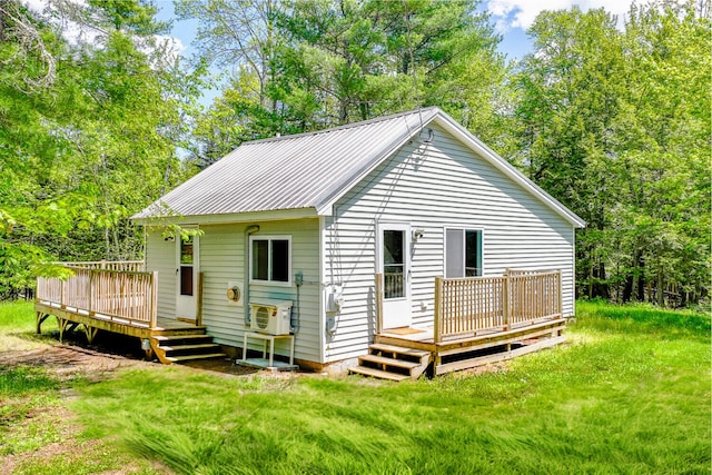 204 Weymouth Rd, Morrill, ME 04952 - back of property featuring a wooden deck, a lawn, metal roof, and ac unit