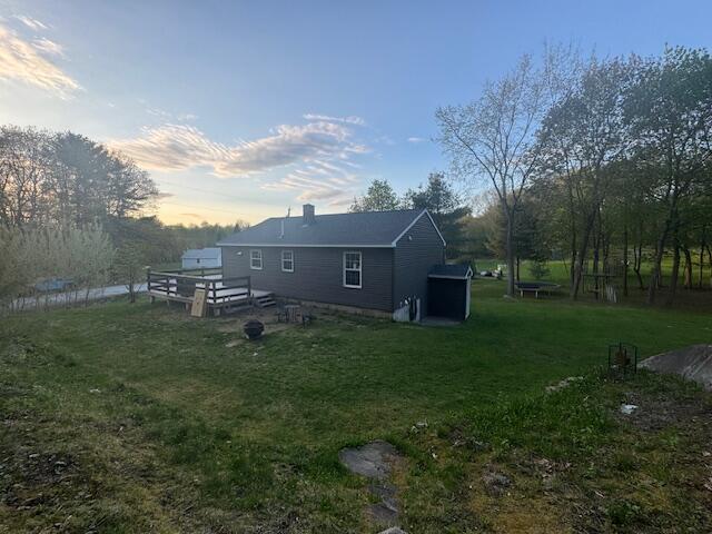 20 Oak Ridge Dr, Chelsea, ME 04330 - back of property at dusk with a lawn and a deck