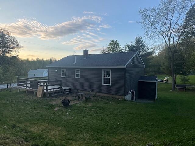 20 Oak Ridge Dr, Chelsea, ME 04330 - back of house at dusk with a wooden deck, a yard, a chimney, and an outdoor fire pit