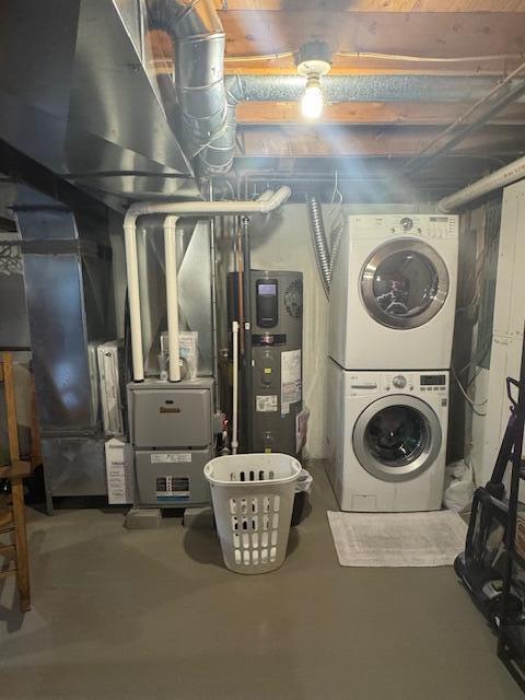 20 Oak Ridge Dr, Chelsea, ME 04330 - unfinished basement with stacked washer and clothes dryer and hybrid water heater