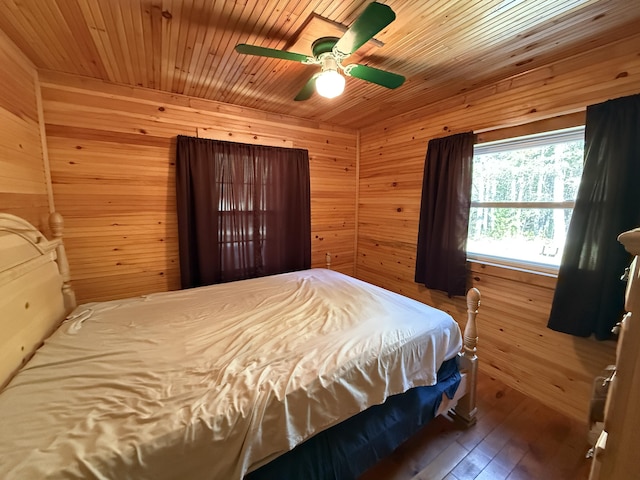bedroom featuring wooden walls, wood-type flooring, a ceiling fan, and wooden ceiling