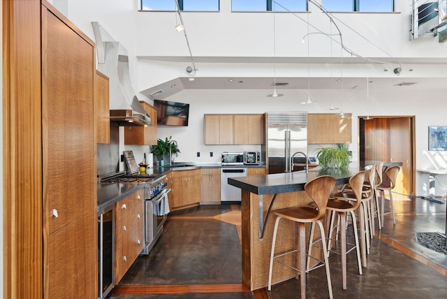 547 Congress St Unit 6, Portland, ME 04101 - kitchen with high quality appliances, wall chimney exhaust hood, dark countertops, a towering ceiling, and modern cabinets