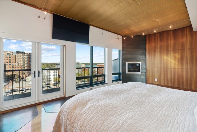 547 Congress St Unit 6, Portland, ME 04101 - bedroom with access to exterior, a large fireplace, wood finished floors, wooden walls, and rail lighting