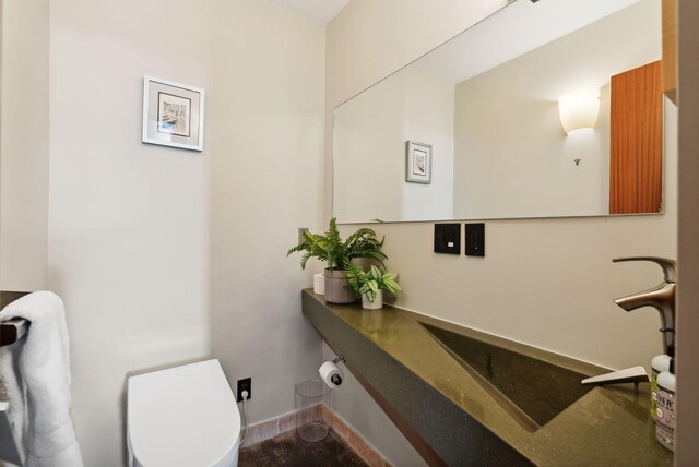 547 Congress St Unit 6, Portland, ME 04101 - bathroom featuring toilet, a sink, baseboards, and wood finished floors