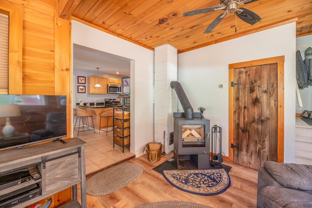 626 Wiscasset Rd, Pittston, ME 04345 - living area with a wood stove, wooden ceiling, a ceiling fan, and light wood finished floors