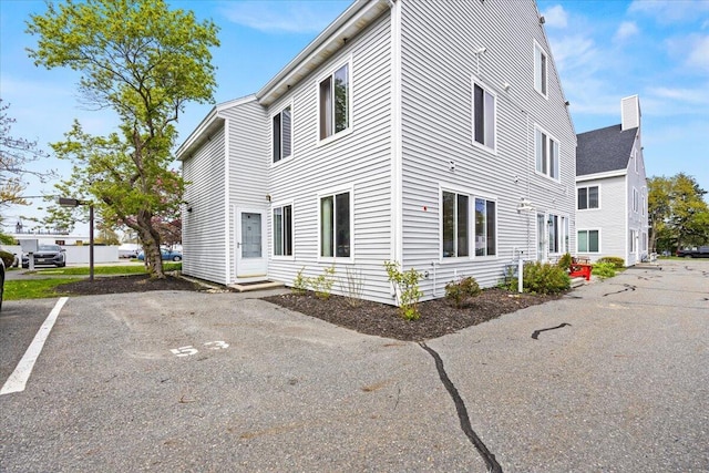 18 Ocean St Unit 72, South Portland, ME 04106 - view of property exterior featuring a chimney, uncovered parking, and entry steps