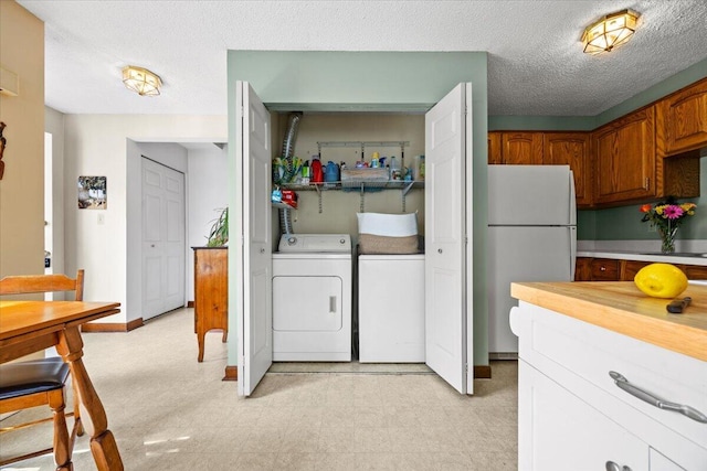 18 Ocean St Unit 72, South Portland, ME 04106 - laundry room featuring washing machine and dryer, light floors, and a textured ceiling