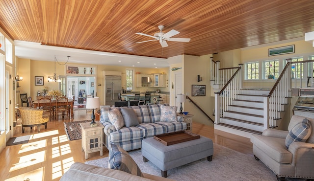 living room featuring wood ceiling, light wood-type flooring, stairway, and ceiling fan