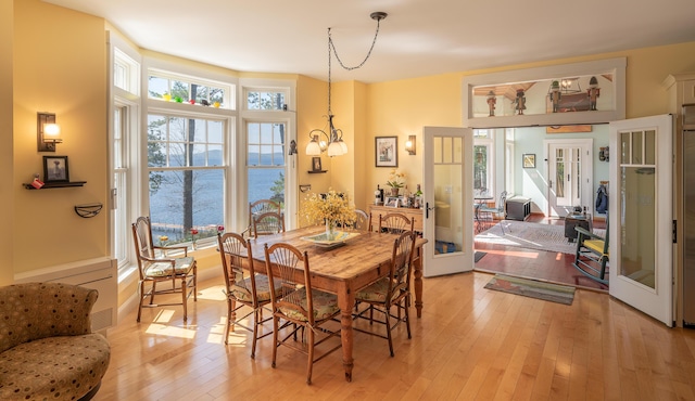 dining space with french doors and light wood-type flooring