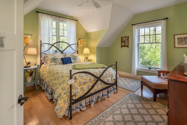 bedroom featuring wood finished floors, vaulted ceiling, a ceiling fan, and baseboards