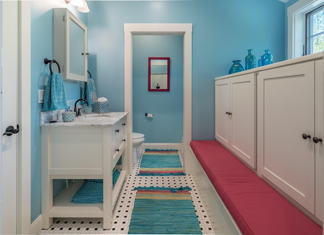 bathroom with baseboards, toilet, and vanity