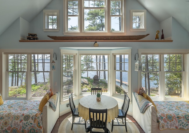 sunroom / solarium with a water view, vaulted ceiling, and french doors