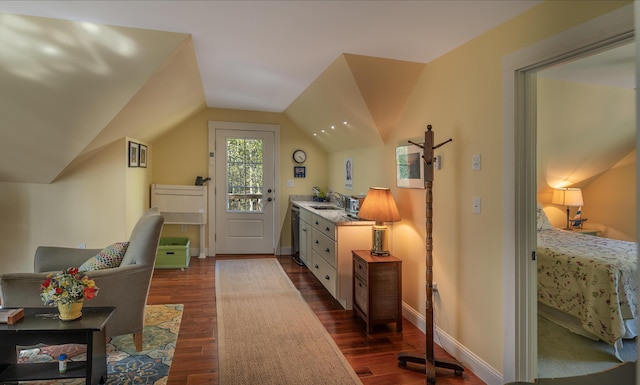 home office with dark wood-type flooring, vaulted ceiling, a sink, and baseboards