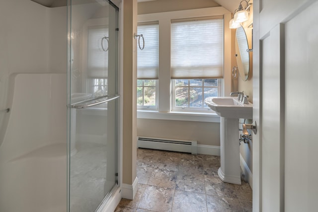 bathroom with a baseboard radiator, a shower stall, baseboards, and stone finish flooring