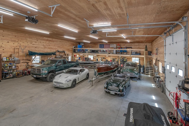 garage featuring wood walls, a workshop area, and a garage door opener