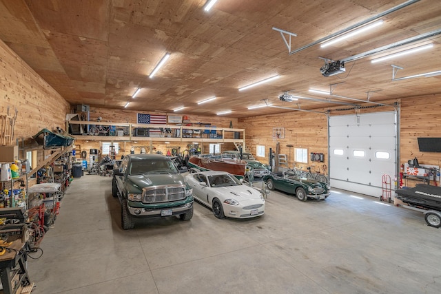 garage with a garage door opener, wooden walls, and a workshop area