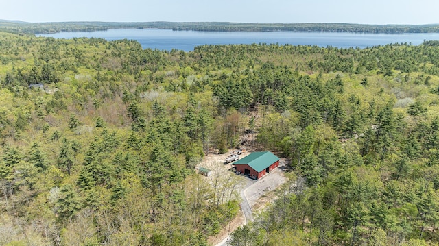 aerial view of property and surrounding area featuring a forest and a large body of water