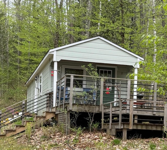 23 Woodland Rd, Winthrop, ME 04364 - view of front of property featuring a view of trees and a wooden deck