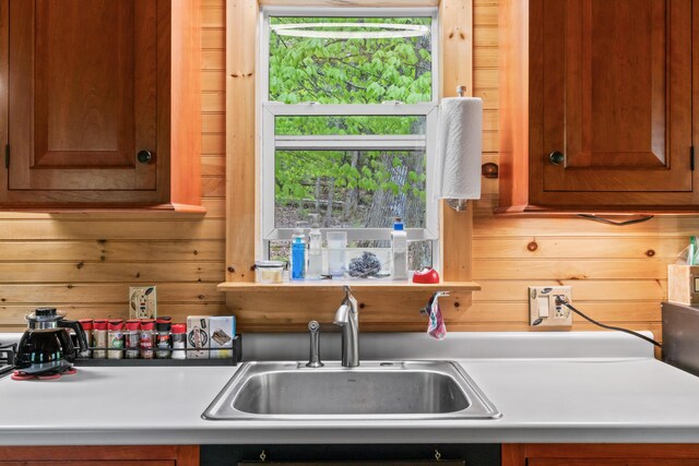 23 Woodland Rd, Winthrop, ME 04364 - kitchen with a sink, wood walls, light countertops, and brown cabinetry