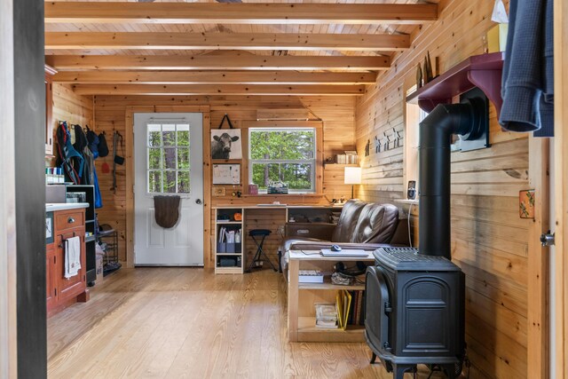 23 Woodland Rd, Winthrop, ME 04364 - home office with beam ceiling, wood walls, light wood-style flooring, a wood stove, and wooden ceiling
