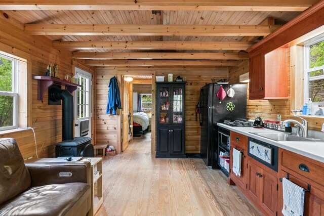 23 Woodland Rd, Winthrop, ME 04364 - kitchen with a sink, wood walls, beamed ceiling, light wood-style floors, and wooden ceiling