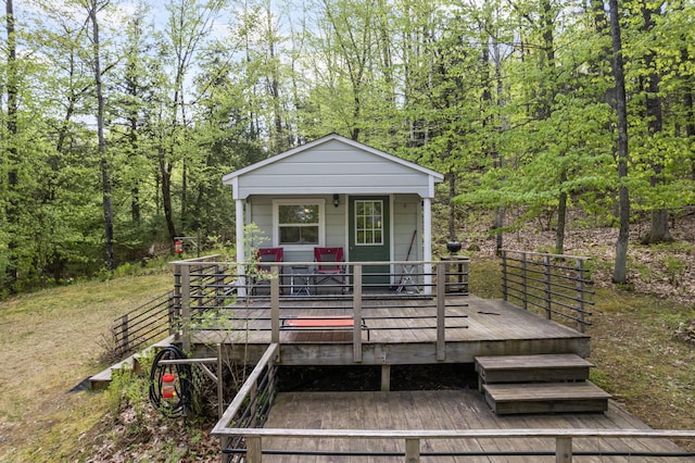 23 Woodland Rd, Winthrop, ME 04364 - view of front of home featuring a wooden deck and a forest view