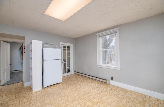 1 High St, Hallowell, ME 04347 - basement with freestanding refrigerator, baseboard heating, a drop ceiling, and baseboards