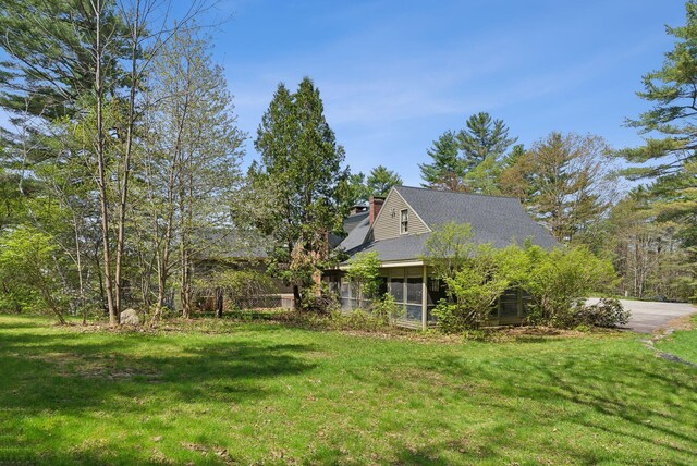 248 Morse Rd, Norway, ME 04268 - view of side of home featuring a chimney, a lawn, a sunroom, and roof with shingles