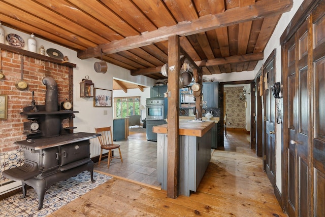 248 Morse Rd, Norway, ME 04268 - kitchen featuring butcher block countertops, a wood stove, beam ceiling, light wood-style floors, and wood ceiling