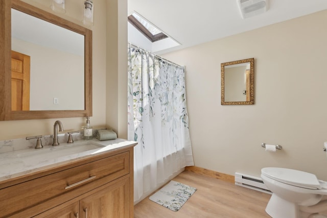 248 Morse Rd, Norway, ME 04268 - bathroom featuring a baseboard heating unit, a skylight, toilet, wood finished floors, and vanity