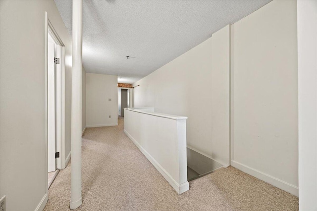 1 Saco Island Ter Unit 308, Saco, ME 04072 - hall featuring an upstairs landing, light carpet, a textured ceiling, and baseboards