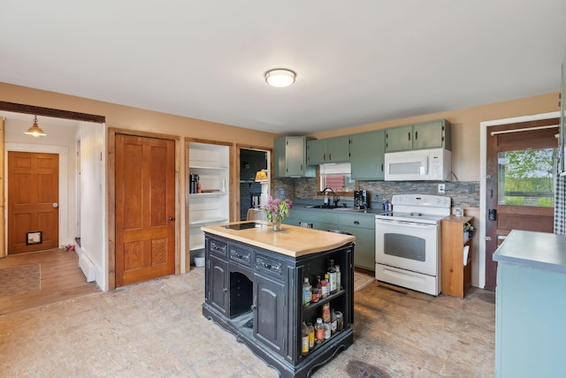 692 S St, Biddeford, ME 04005 - kitchen featuring white appliances, a center island with sink, tasteful backsplash, light countertops, and green cabinets