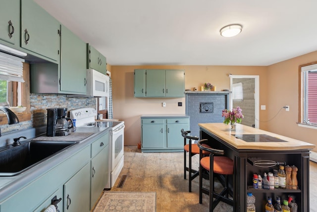 692 S St, Biddeford, ME 04005 - kitchen with white appliances, a sink, plenty of natural light, and decorative backsplash