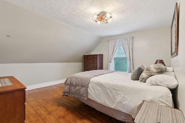 692 S St, Biddeford, ME 04005 - bedroom featuring a textured ceiling, hardwood / wood-style floors, baseboards, and vaulted ceiling