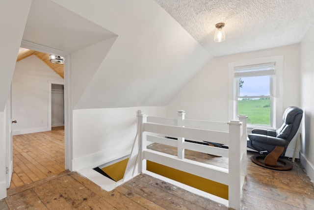 692 S St, Biddeford, ME 04005 - additional living space featuring wood-type flooring, lofted ceiling, and a textured ceiling