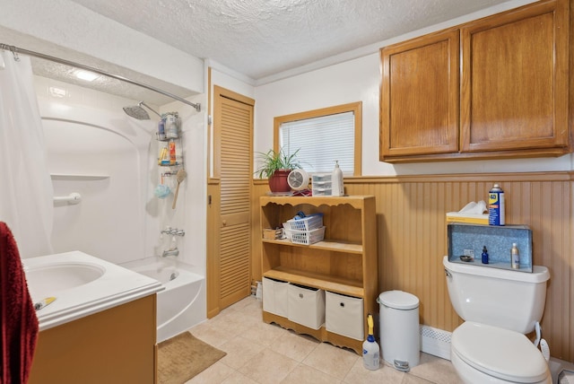 692 S St, Biddeford, ME 04005 - full bath featuring shower / bath combination with curtain, toilet, a textured ceiling, wainscoting, and tile patterned floors
