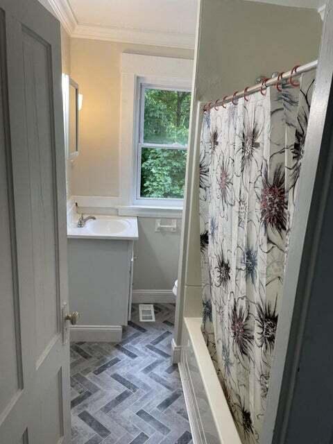 30 Patterson St, Augusta, ME 04330 - bathroom with ornamental molding, vanity, toilet, baseboards, and shower / bath combo with shower curtain
