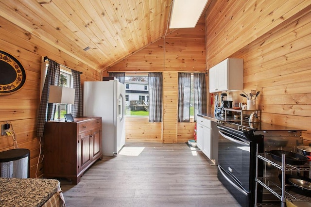 45AND57 Southgate Rd, Kennebunk, ME 04043 - kitchen with wooden walls, black / electric stove, white refrigerator with ice dispenser, vaulted ceiling, and hardwood / wood-style flooring