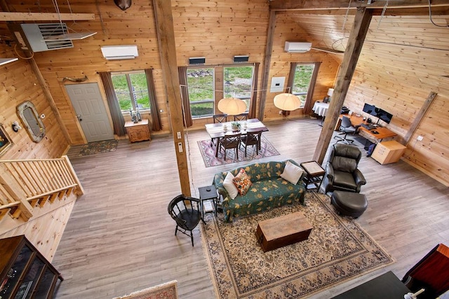 45AND57 Southgate Rd, Kennebunk, ME 04043 - living area with wooden walls, wood finished floors, a wall mounted AC, and a towering ceiling