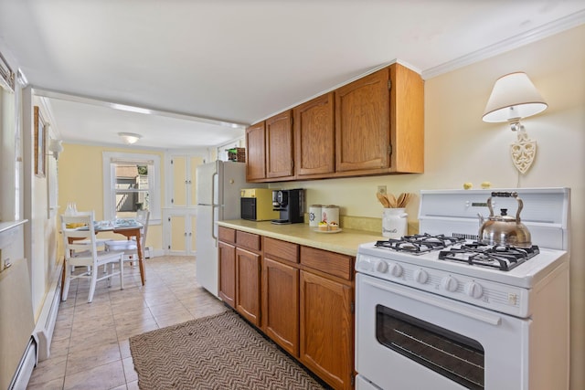 19 Fairhaven Ave, Saco, ME 04072 - kitchen featuring white appliances, light countertops, brown cabinetry, light tile patterned flooring, and baseboards