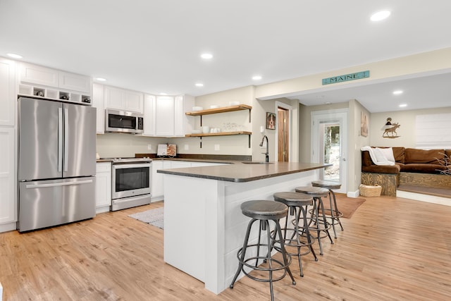 10 E Pinnacle Rd Unit 10, Bridgton, ME 04009 - kitchen with appliances with stainless steel finishes, dark countertops, white cabinetry, light wood finished floors, and recessed lighting