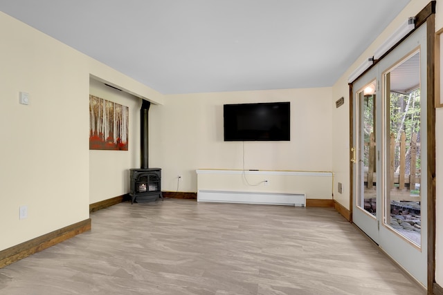10 E Pinnacle Rd Unit 10, Bridgton, ME 04009 - unfurnished living room featuring a baseboard heating unit, baseboards, and a wood stove