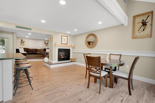 10 E Pinnacle Rd Unit 10, Bridgton, ME 04009 - dining space featuring light wood-type flooring, a glass covered fireplace, baseboards, and recessed lighting