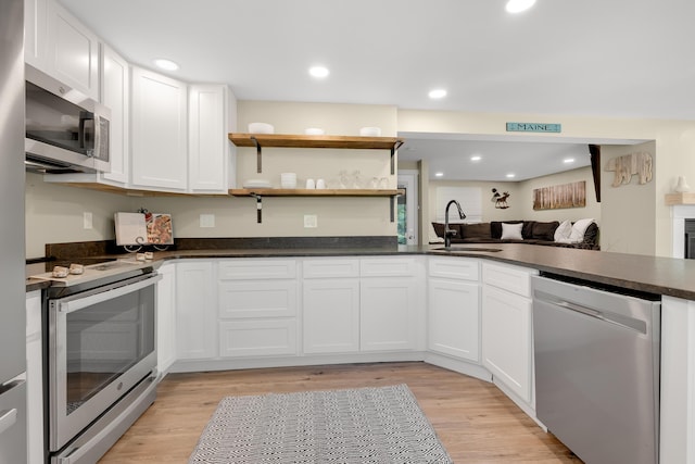 10 E Pinnacle Rd Unit 10, Bridgton, ME 04009 - kitchen with stainless steel appliances, a sink, light wood-style flooring, dark countertops, and recessed lighting