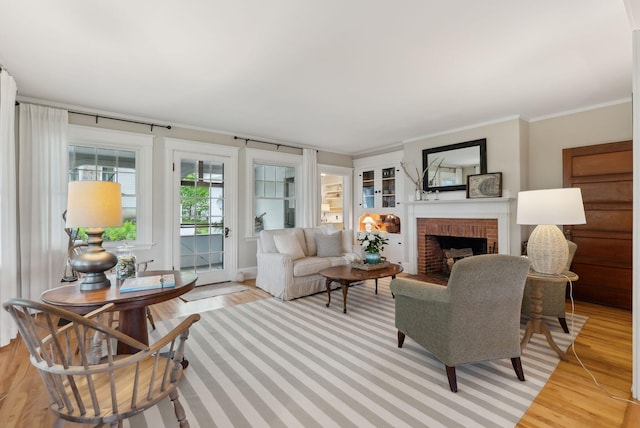 14 Oak St, Kennebunk, ME 04043 - living area featuring light wood finished floors, a brick fireplace, and crown molding