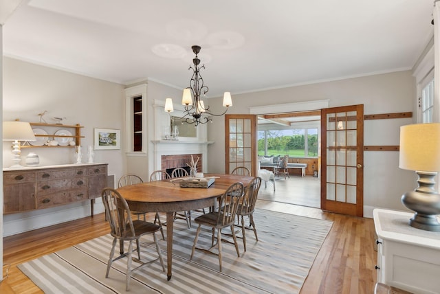 14 Oak St, Kennebunk, ME 04043 - dining area featuring light wood finished floors, a chandelier, french doors, and ornamental molding