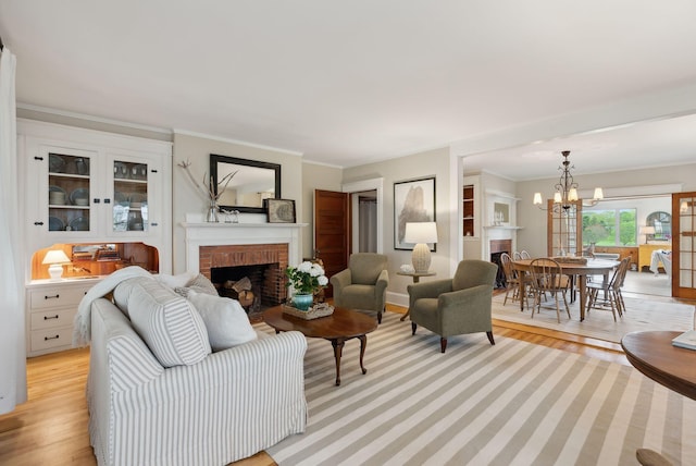 14 Oak St, Kennebunk, ME 04043 - living room featuring a fireplace, light wood-type flooring, a chandelier, and ornamental molding